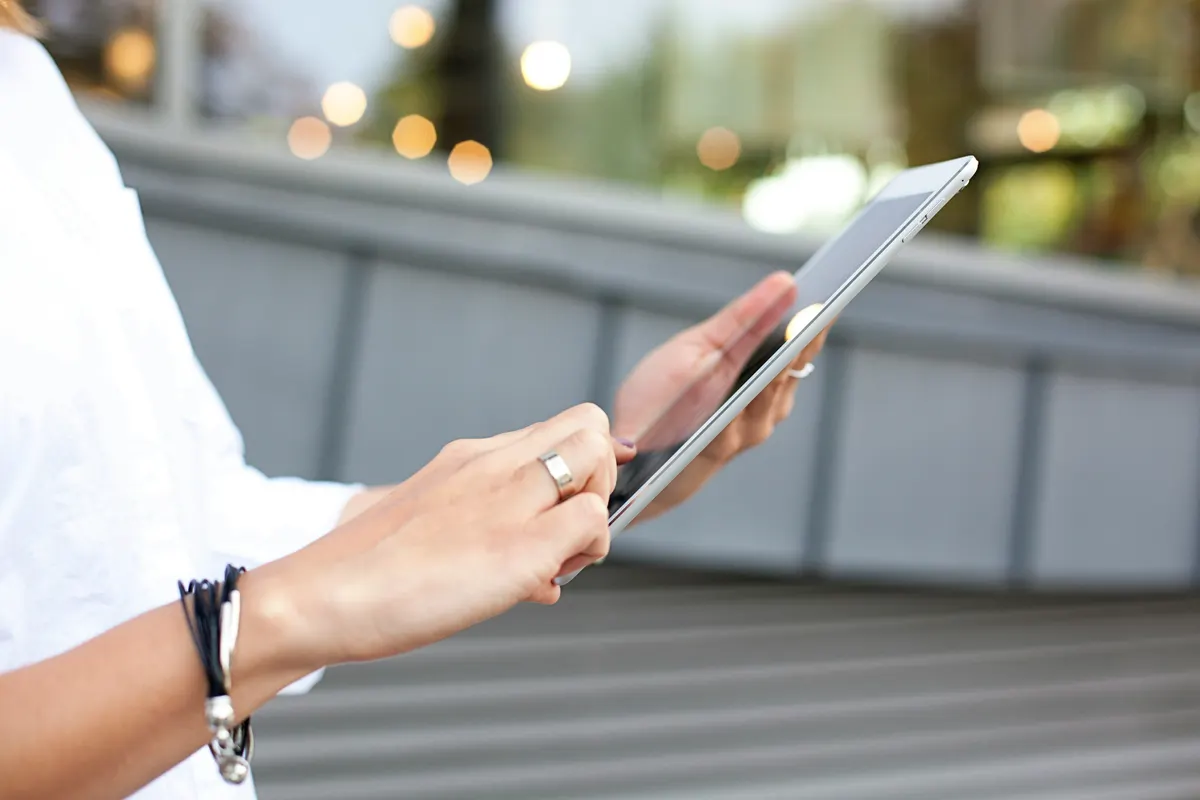 Hände bedienen eine Anwendung auf dem Tablet