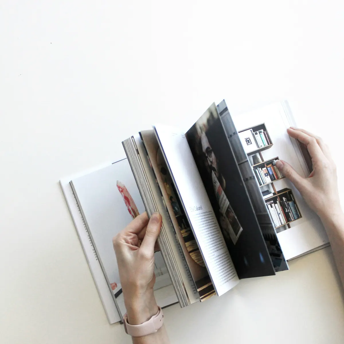 Hände blättern durch einen aufgeschlagenen Katalog
